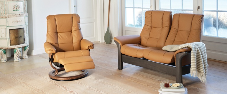 Tan leather sofa and recliner chair set in a bright, Scandinavian-style living room